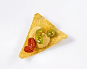 A nacho chip with cheese dip (close-up)