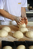 Baker shaping bread rolls