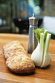 Ciabatta, fennel bulb and pepper shaker, barbecue behind