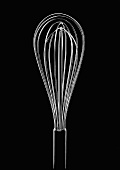 A whisk against a black background