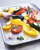 Raw vegetables with olive oil on baking tray (for roasting)