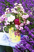 Verschiedene Rosen auf einem Stuhl im Lavendelfeld