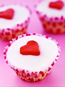 Three cupcakes decorated with marzipan hearts