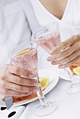 Hands clinking glasses of rosé wine together