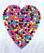 Coloured chocolate beans forming heart
