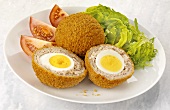 Scotch eggs (hard-boiled eggs wrapped in sausage meat) with salad