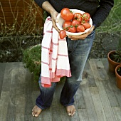 Mann hält Schüssel mit frischen Tomaten