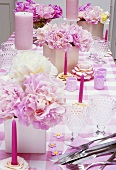 Gedeckter Tisch mit rosa Accessoires & Pfingstrosen