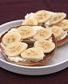 Toasted bagel topped with soft cheese and banana slices
