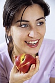 Young woman holding a nectarine