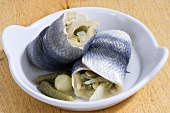 Two rollmops in white dish