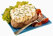 A baked potato with cottage cheese and chives