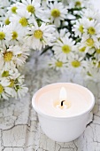 A candle and asters