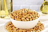Salted peanuts in small bowl and on plate