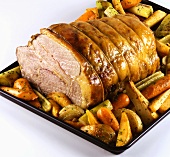 Roast pork with root vegetables in roasting tin