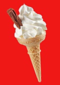 Soft vanilla ice cream and chocolate flake in wafer cone