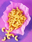 Elbow pasta, partly on greaseproof paper