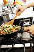 Stir-frying vegetables in wok