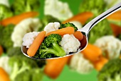 Mixed vegetables on a spoon and in background