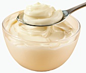 Mayonnaise in a glass bowl and on a spoon