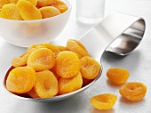 Dried apricots on a spoon and in a bowl
