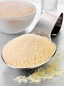 Golden sugar on a spoon and in a glass bowl