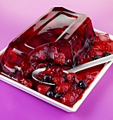 Mixed berry jelly on a plate with a spoon
