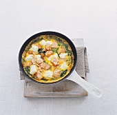 Salmon, cheese and spinach omelette in a frying pan