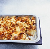 Bread and butter pudding with dried fruit in a baking tin