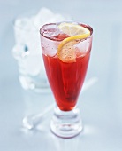 Red cocktail with soda water over ice