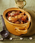 Chicken in a casserole dish with vegetables, herbs and bacon