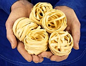 Hands holding tagliatelle