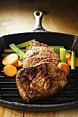 Beef steaks with vegetables in grill pan