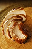 Sliced smoked chicken breast on chopping board