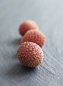 Three unpeeled lychees