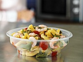 Pasta salad with prawns in plastic container to take away