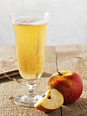 A glass of cider with apple