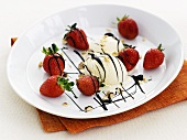 Ice-cream with strawberries, cashew nuts and chocolate sauce