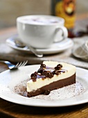 A slice of cheesecake with a cappuccino