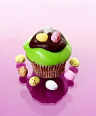 Muffin with green icing and chocolate eggs