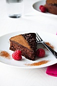 A piece of chocolate cake with fresh raspberries