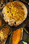 Currypulver und verschiedene Gewürze auf Baumrinde