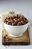 Bowl of hazelnuts on old wooden board