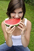 Young woman biting into a slice of watermelon