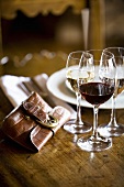 Glasses of different wines, place-setting and purse
