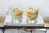 Yoghurt with peach and hazelnuts in two glasses