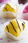 Yellow and pink petit fours in paper cases