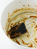 Empty bowl with the remains of carrot cake mixture, spatula