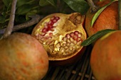 Several pomegranates, whole and halved