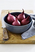 Red onions in bowl on chopping board